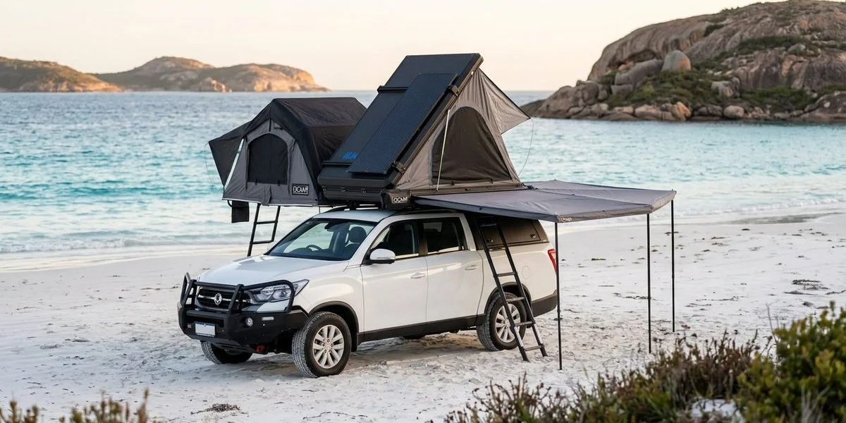 A 4WD camper vehicle parked on the pristine white sand of Lucky Bay with crystal clear turquoise water and granite headlands beyond